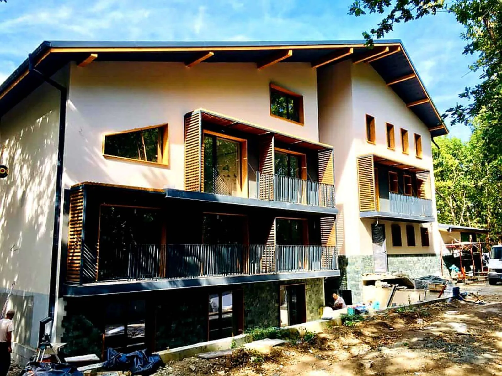 Modern mountain guest house with green cut stone cladding on the lower floors