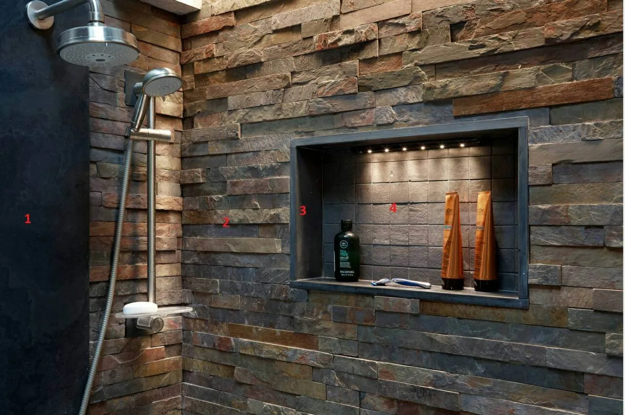 Shower walls clad with stacked slate stone strips and a lit niche
