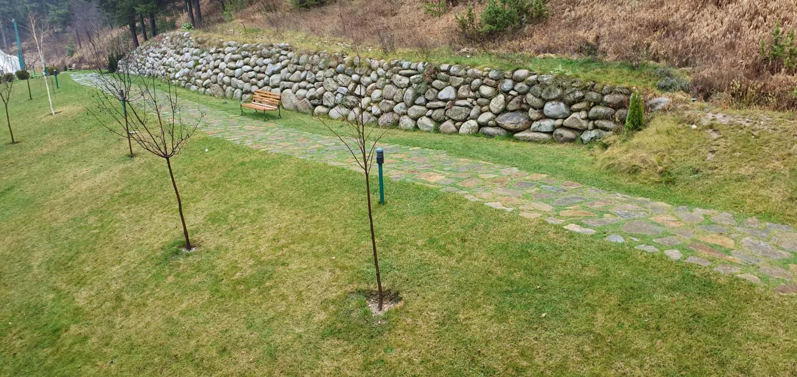 Landscaped garden with boulder retaining wall and flagstone pathway