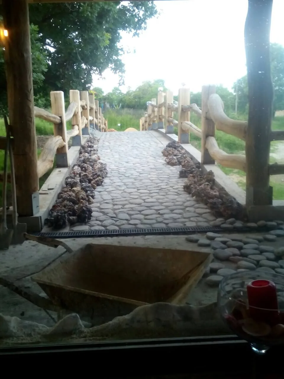 Garden walkway paved with river pebbles bordered by rustic wooden railings