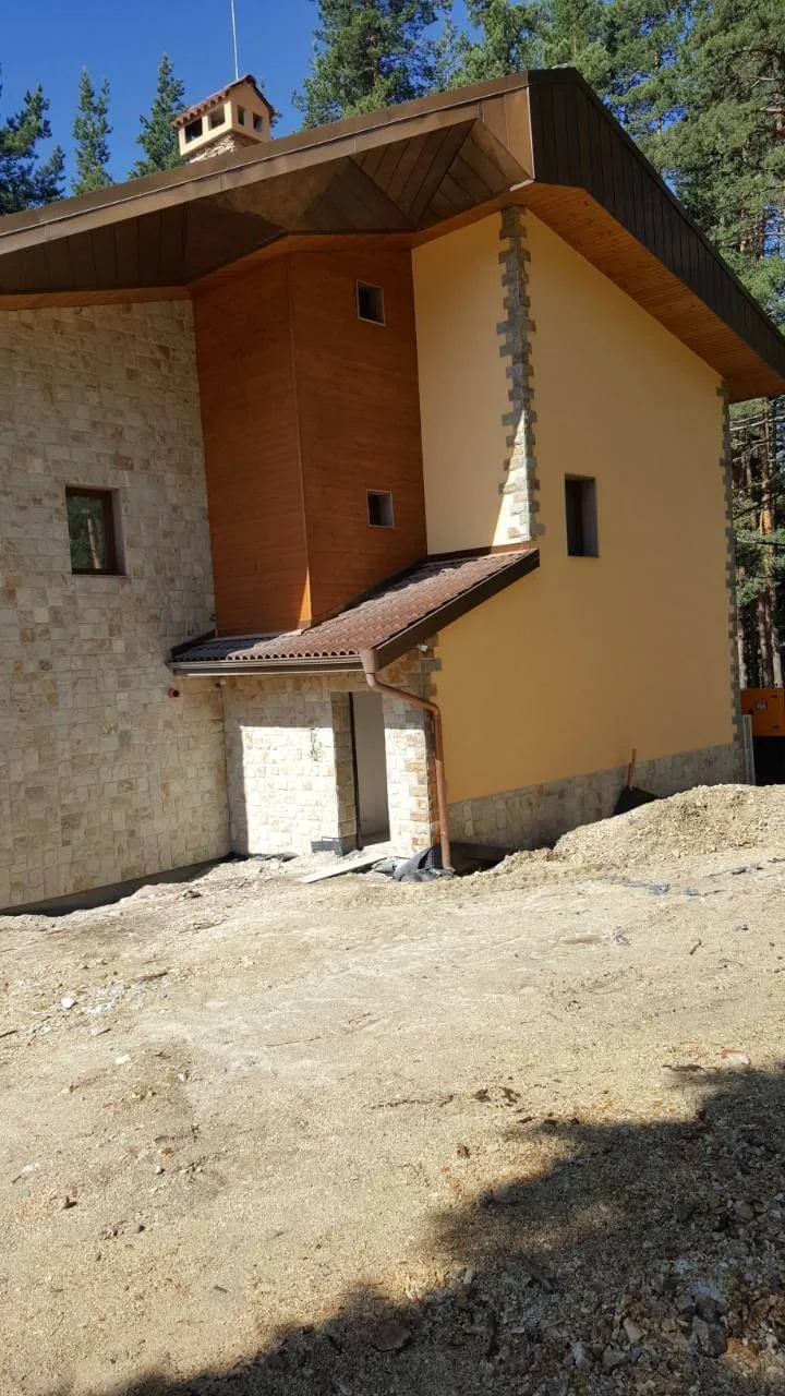 Mountain house facade with cut stone tile cladding and stone corner quoins