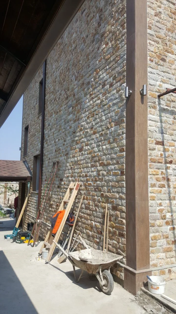 Large house facade covered with rustic rubble stone cladding