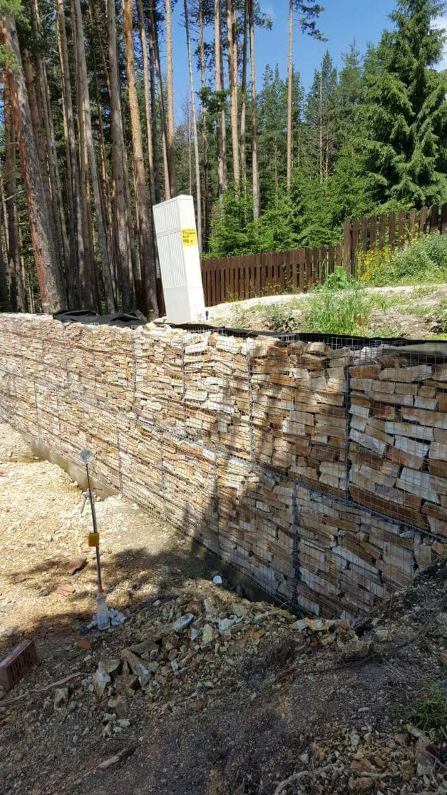 Gabion retaining wall filled with natural gneiss rubble at a forest site