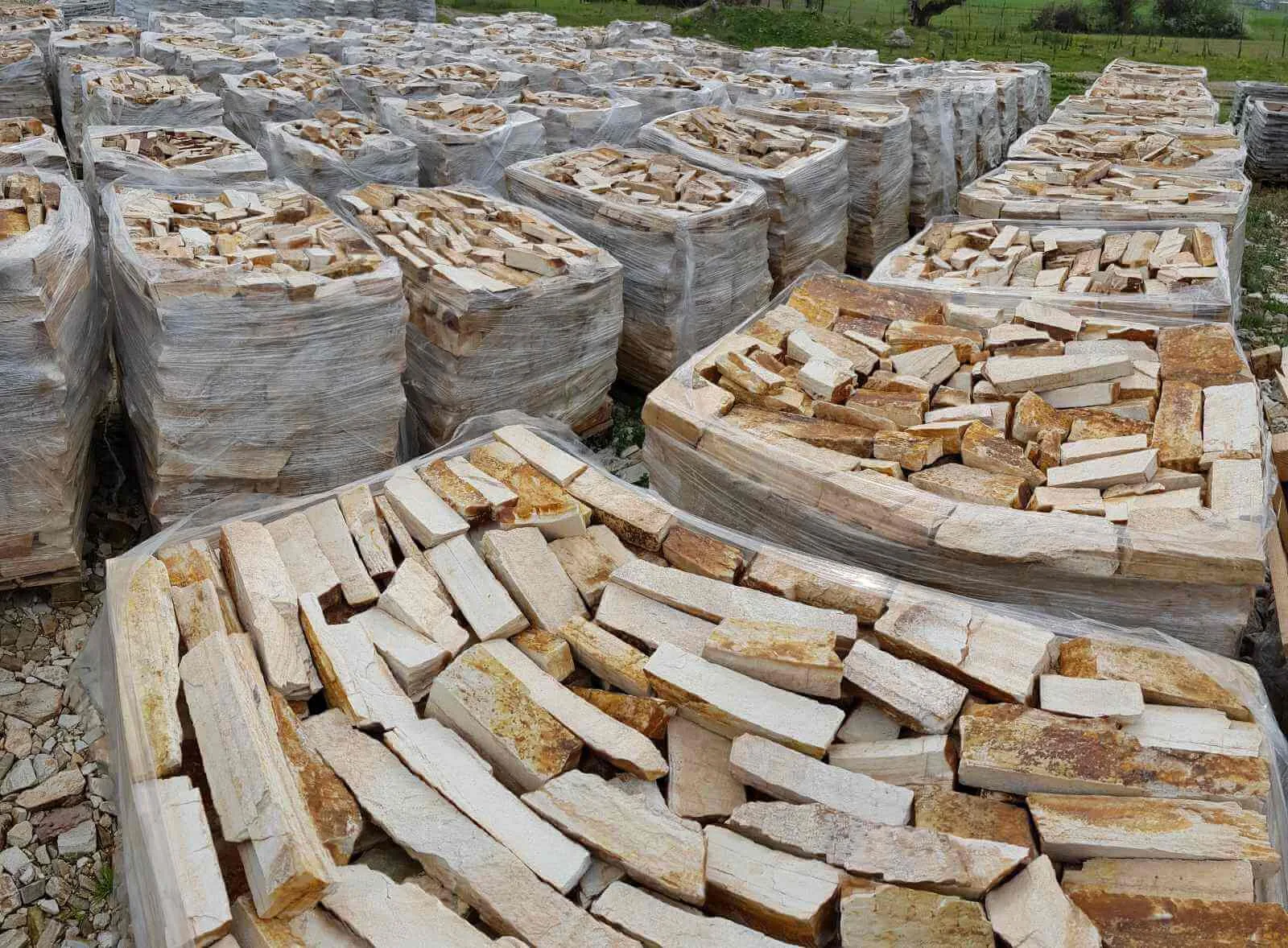 Palletized cream rubble stone strips at the stone yard