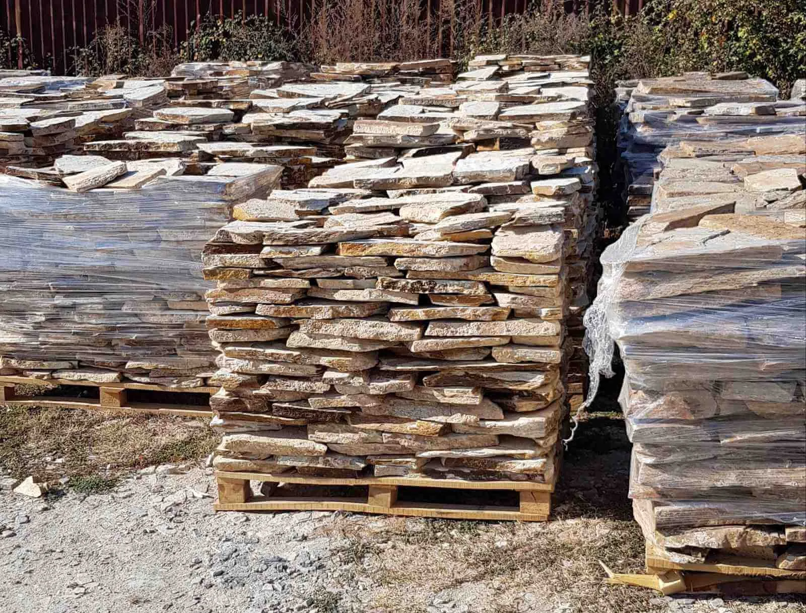 Pallets of stacked rustic gneiss flagstones at the storage yard