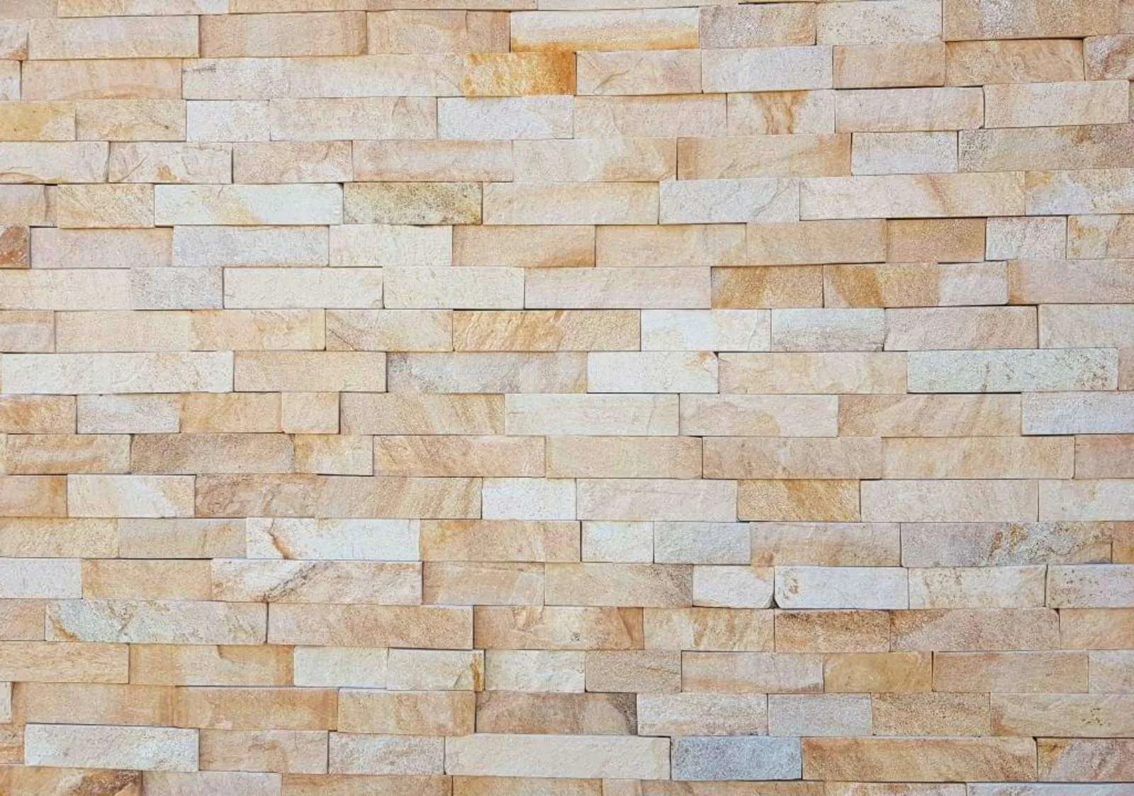 Wall clad with precision-cut beige and cream gneiss strips.