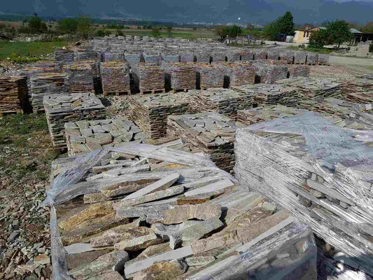 Extensive stone yard filled with pallets of gneiss strips and flagstones.