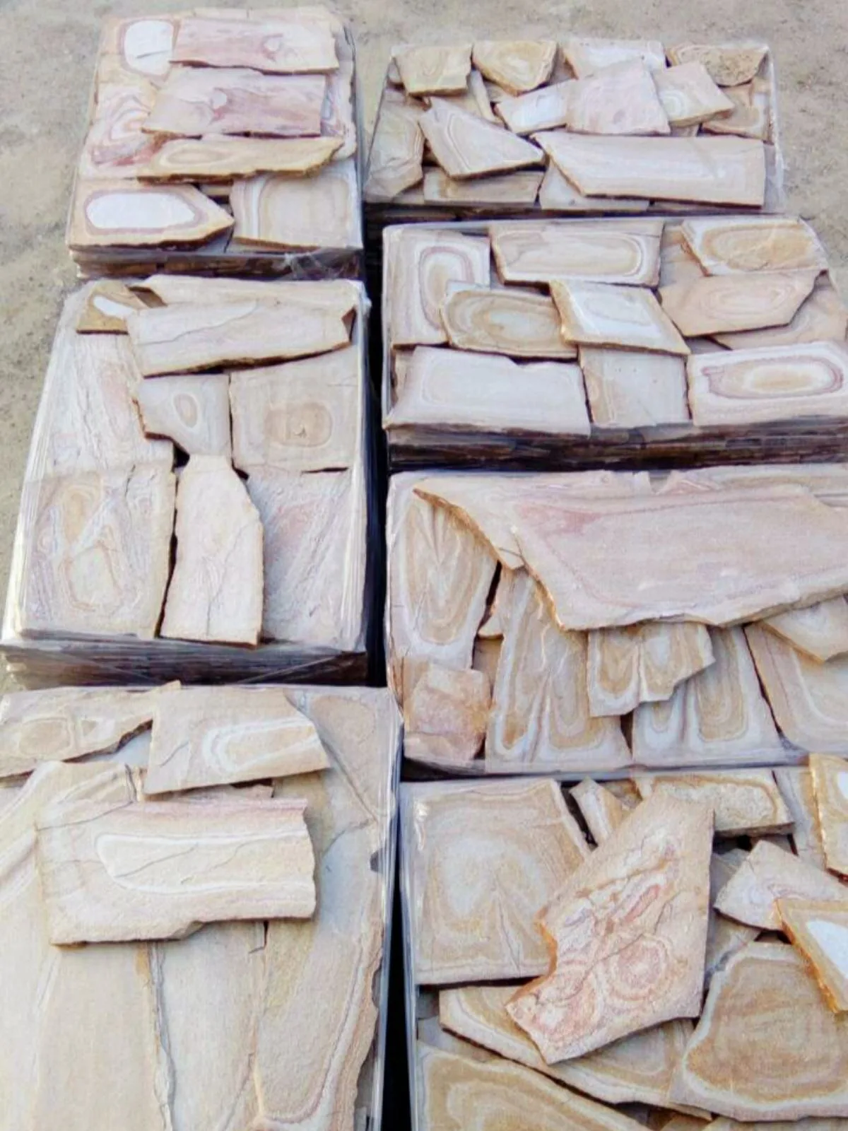 Pallets of pale pink patterned gneiss flagstones seen from above