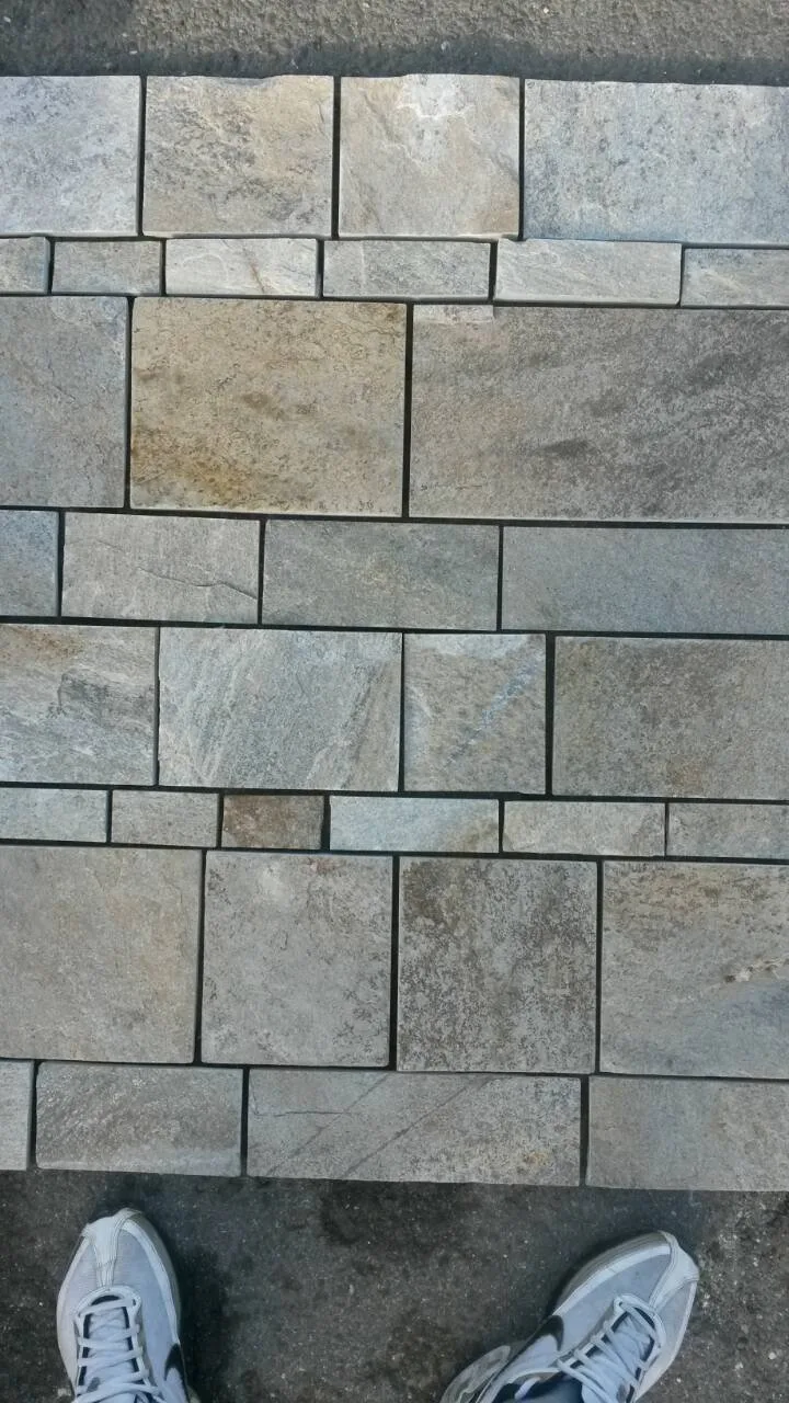 Modular pattern of precision-cut gneiss paving tiles laid out at the yard