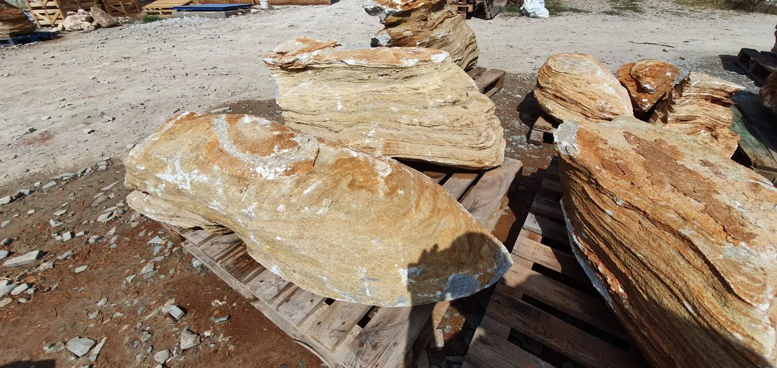 Sculptural decorative garden rocks on wooden pallets at the stone yard