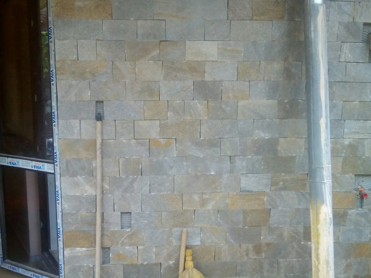 Facade wall clad with gray rectangular cut gneiss pieces
