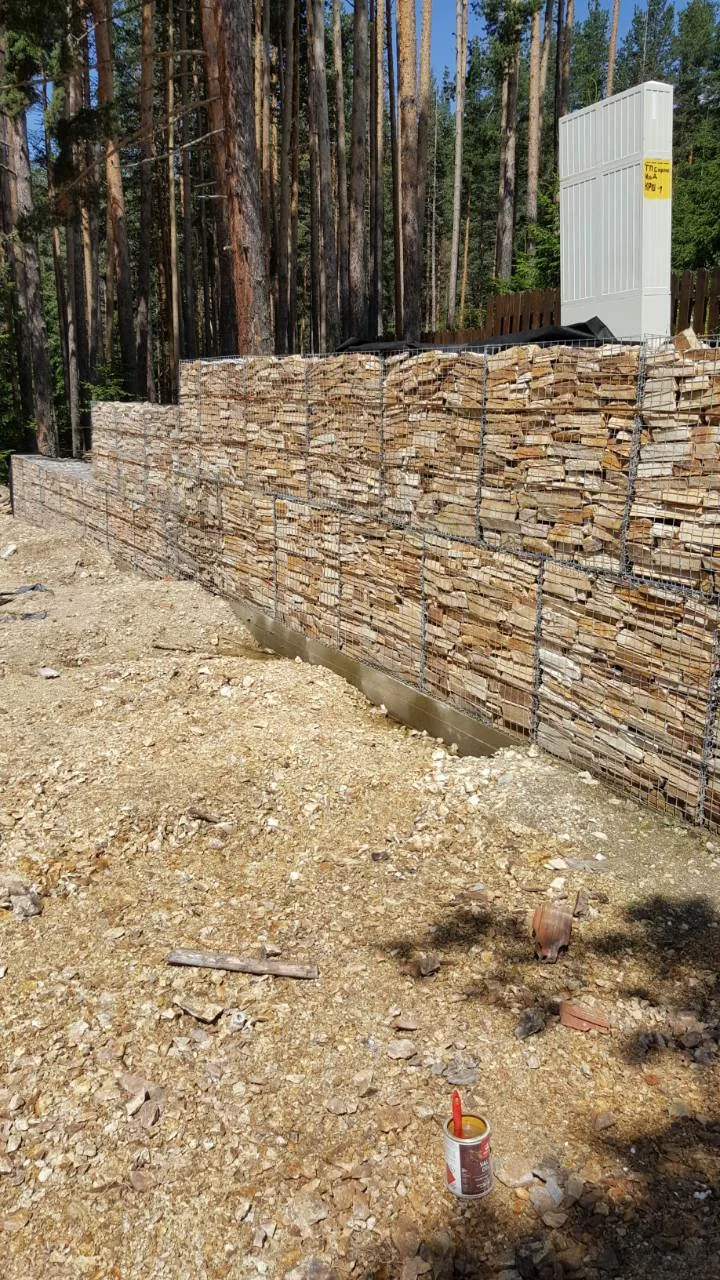 Gabion retaining wall filled with gneiss rubble stone in a pine forest