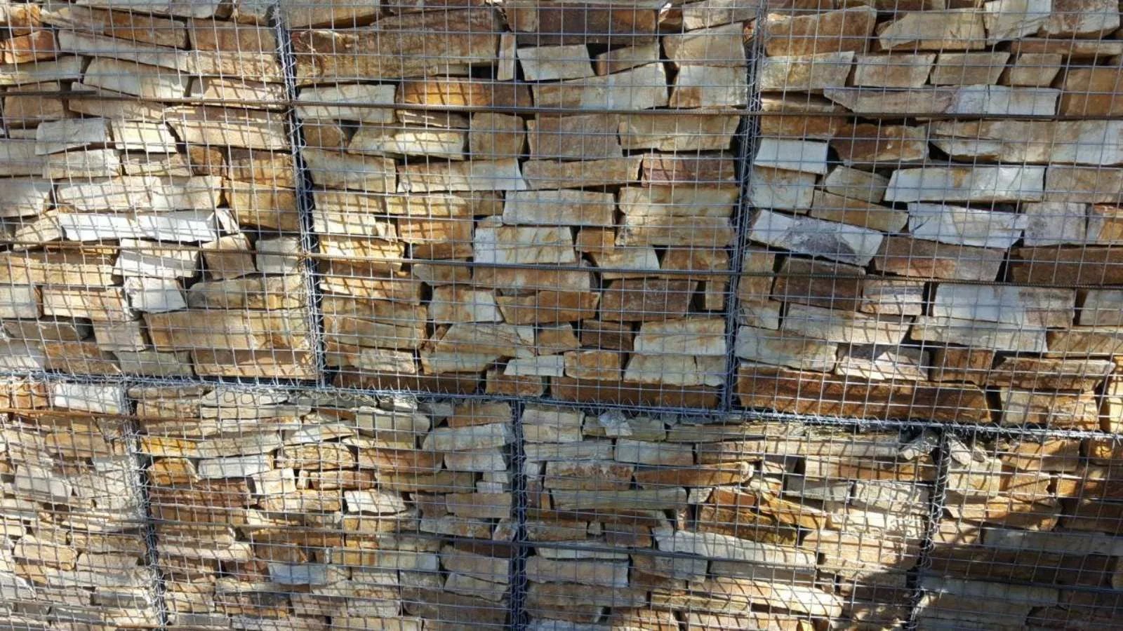 Close-up of a gabion wall filled with layered rubble stone