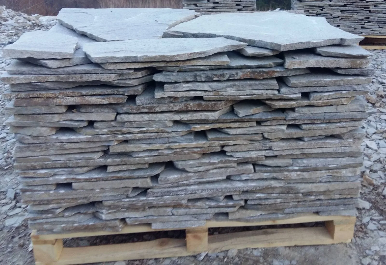 Large irregular gneiss slabs stacked on a wooden pallet