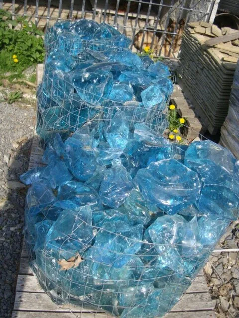 Wire baskets filled with decorative blue glass rocks in the stone yard