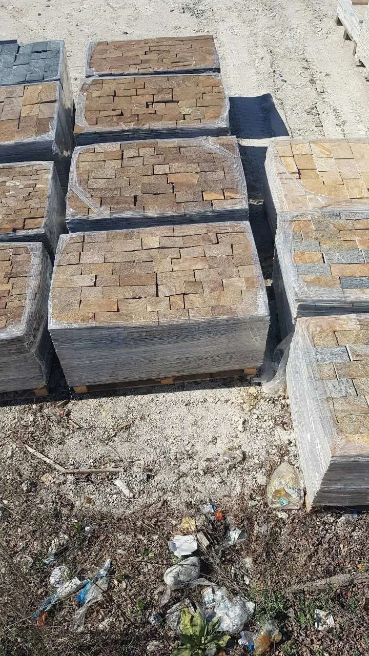 Wrapped pallets of cut gneiss cladding pieces stacked at the production yard