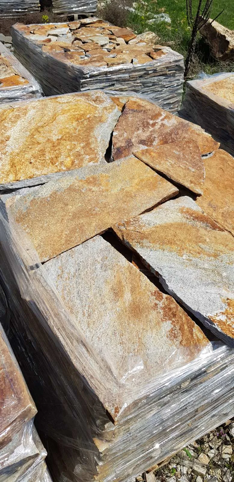 Pallets of irregular gneiss flagstones wrapped in foil for transport