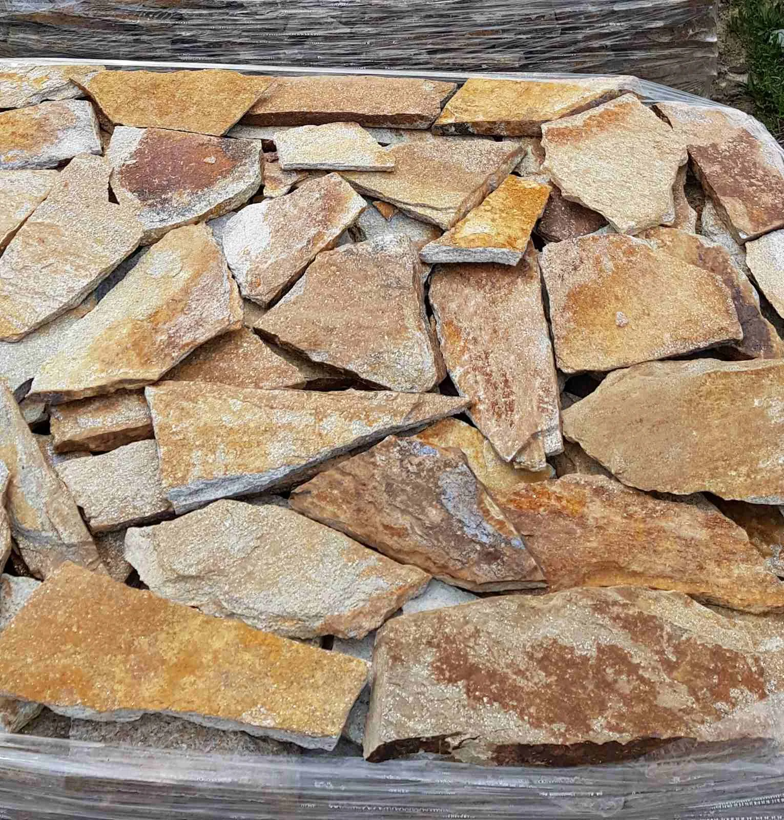 Close-up of natural irregular gneiss flagstones stacked on a pallet