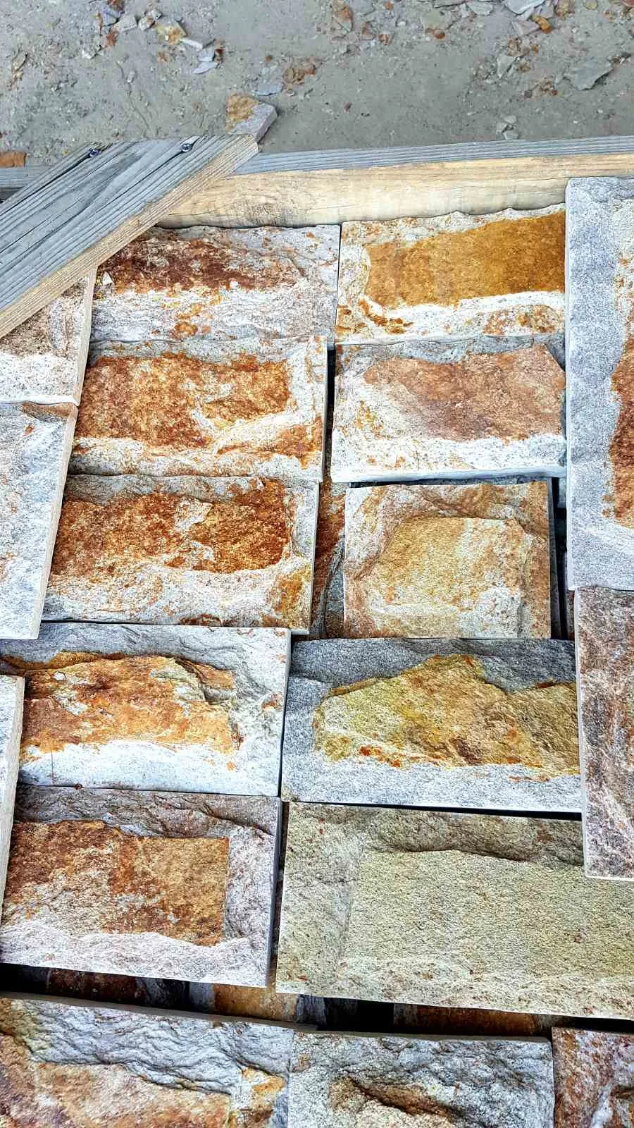 Close-up of rock-face rectangular gneiss cladding pieces on a pallet