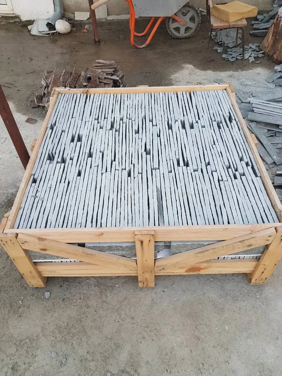 Wooden crate packed with thin cut grey gneiss strips