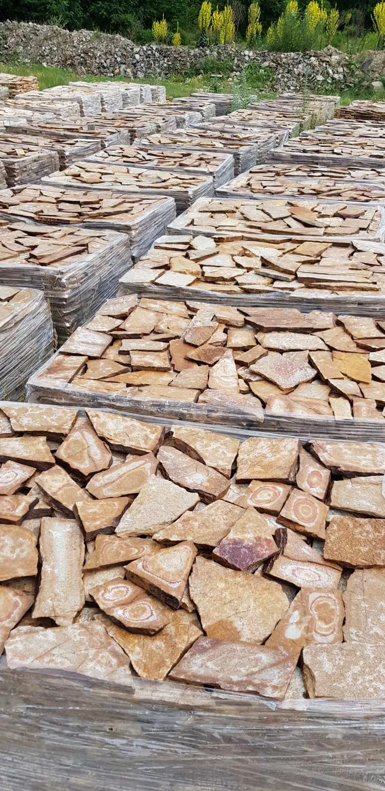 Rows of pallets with irregular gneiss flagstones at the storage yard