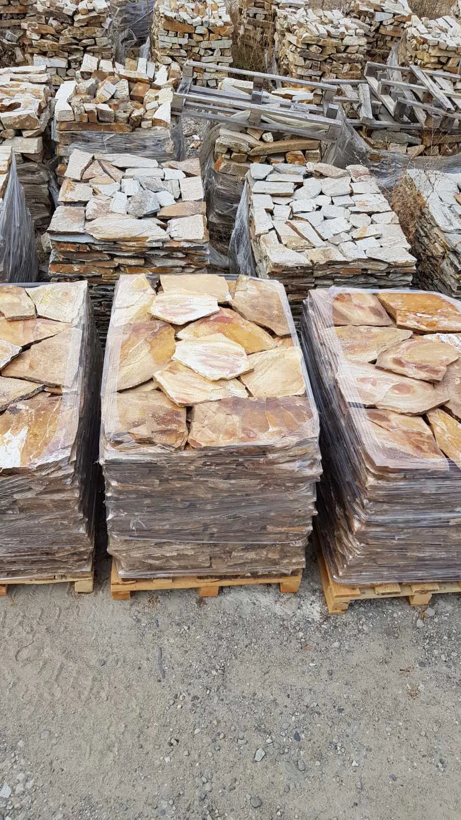 Palletized irregular gneiss flagstones stacked in the production yard