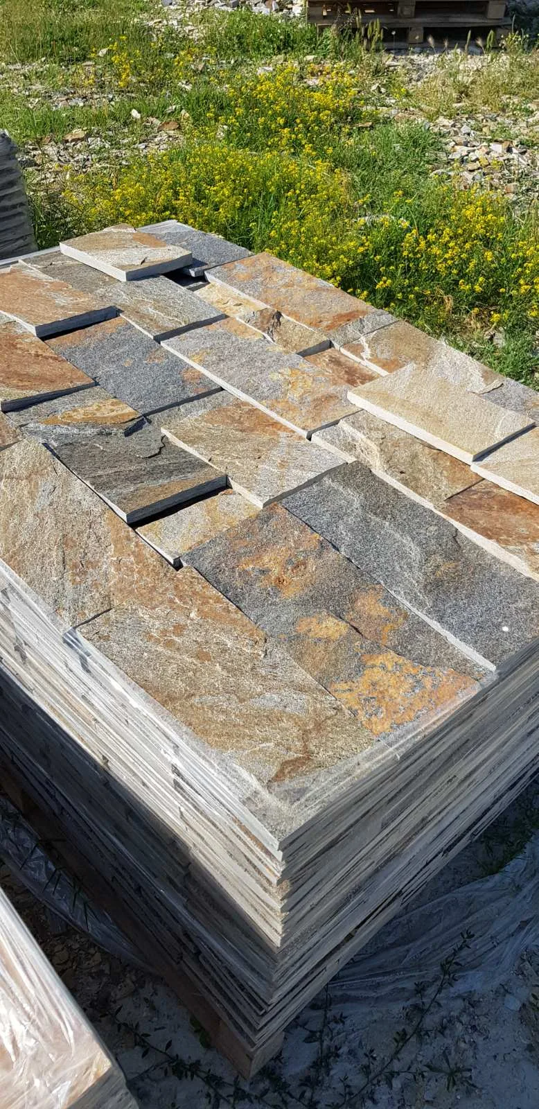 Pallet of cut rustic gneiss cladding slabs at the stone yard